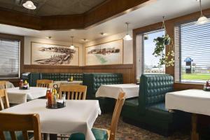 a restaurant with white tables and green booths and chairs at Days Inn by Wyndham Rock Falls in Rock Falls