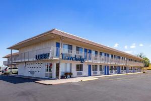 un gran edificio con un cartel en la parte delantera en Travelodge by Wyndham Miles City, en Miles City