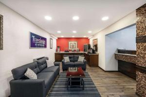 a living room with couches and a flat screen tv at Travelodge by Wyndham Miles City in Miles City
