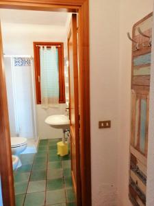 a bathroom with a sink and a toilet and a mirror at Villa Perla in Capoliveri