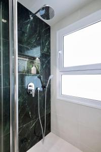 baño con ducha y ventana en Segundo Molo Suites en Tesalónica