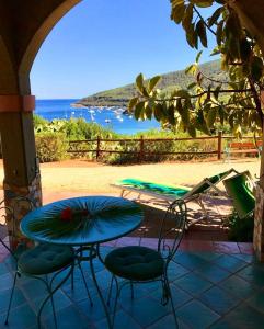 a patio with a table and chairs and the ocean at Villa Perla in Capoliveri