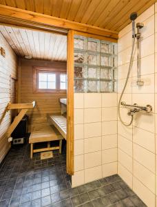 a sauna with a bench and a shower at Mäntyruka Cottages in Ruka