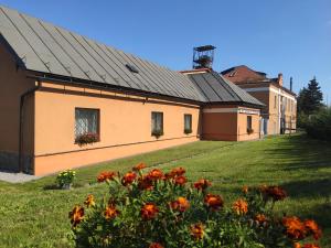 ein Gebäude mit einem Garten mit Blumen im Vordergrund in der Unterkunft Ubytovanie na Frantšachte in Banská Štiavnica