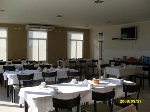 a dining room with white tables and chairs at LS Hotel in Salta