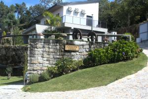 ein Haus mit einem Schild an einer Steinmauer in der Unterkunft Quinta dos Lagos in Marco de Canavezes