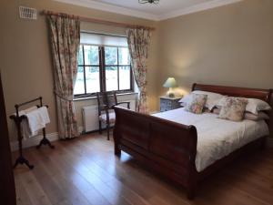 1 dormitorio con cama y ventana grande en Croagh Patrick Lodge Apartment, en Westport