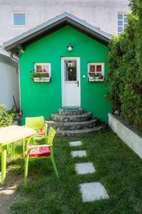 a green house with a table and chairs in front of it at Sweet Home in Valjevo