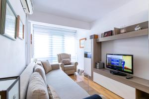 uma sala de estar com um sofá e uma televisão em Ifema Aeropuerto em Madri