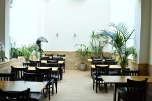 um restaurante com mesas de madeira, cadeiras e plantas em Hotel Münchner Hof em Frankfurt am Main