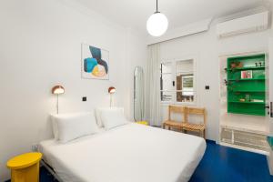 - une chambre avec un lit blanc et un tabouret jaune dans l'établissement AiR White Tower Apartment, à Thessalonique