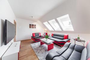 ein Wohnzimmer mit 2 Sofas und einem TV in der Unterkunft Apartman SEGATI in Slavičín