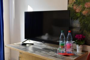a television with three bottles on a table at Hotel Münchner Hof in Frankfurt