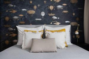ein Bett mit vier Kissen in einem Schlafzimmer mit einer Tapete in der Unterkunft Easy Rent Apartments - Centrum 2 in Lublin