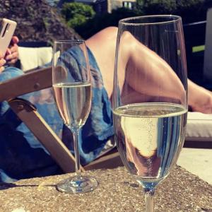 two glasses of wine sitting on a table with a woman at The Old Thatch - Hennock in Newton Abbot