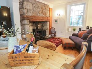 a living room with a table and a fireplace at Tan Y Bryn in Beaumaris