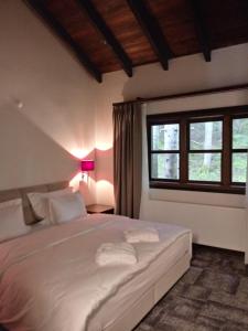 a bedroom with a large white bed with a window at North Chalets in Giresun