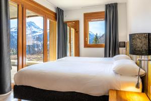 um quarto com uma cama grande e vista para a montanha em FranceComfort - AlpChalets Portes du Soleil em Abondance