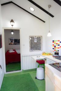a kitchen with a green floor and a bedroom at Sweet Home in Valjevo