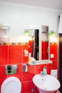 a red and white bathroom with a sink and a toilet at Sweet Home in Valjevo +53 photos