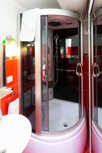 a shower in a train bathroom with red walls at Sweet Home in Valjevo