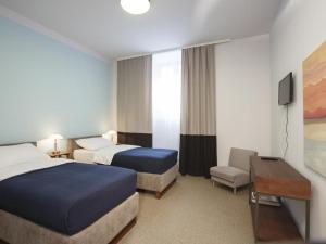 una camera d'albergo con due letti e una televisione di Savamala b&b a Belgrado