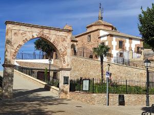 a building with an archway in front of a building at San Miguel in Membrilla