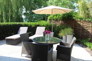 einen Tisch und Stühle mit Sonnenschirm auf einer Terrasse in der Unterkunft B Apartment in Bierbeek