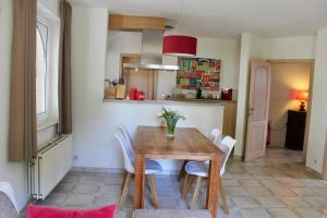 kuchnia i jadalnia z drewnianym stołem i krzesłami w obiekcie B Apartment w mieście Bierbeek