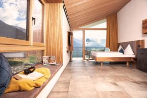 a room with a bedroom with a bed and a fireplace at Panorama Lodges Plagött in San Valentino alla Muta