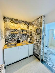 a kitchen with white cabinets and a tile wall at Private Place to Stay self check in-nonstop- NETFLIX-WIFI in Reşiţa