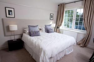 a bedroom with a large white bed with blue pillows at Brucefield Boutique B&B in Arbroath