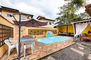 a patio with a table and chairs and a pool at Pousada Acqua Marina in Paraty