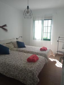 twee bedden in een slaapkamer met rode kussens erop bij Apartamento Maresia in Puerto del Carmen