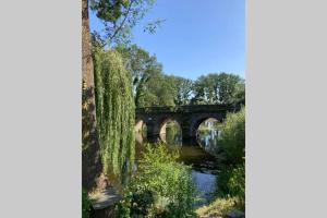 a bridge over a river in a park at STUDIO indépendant Segré in Segré