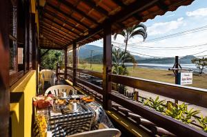 a table on a balcony with a view of the water at Pousada Acqua Marina in Paraty
