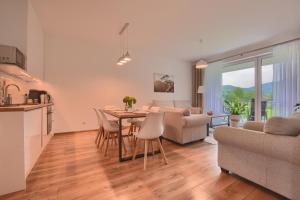 a kitchen and living room with a table and chairs at Apartamenty MIWA in Szczyrk