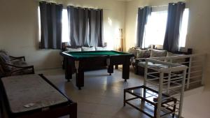 a living room with a ping pong table in it at Incrivel casa com churrasq e piscina em Peruibe in Peruíbe