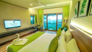 a hotel room with a bed with a television and a room at Grand Palace Hotel & Spa in Yercaud