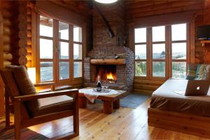 Una sala de estar con chimenea en una cabaña de troncos en Hyades Mountain Resort, en Kato Trikala Korinthias