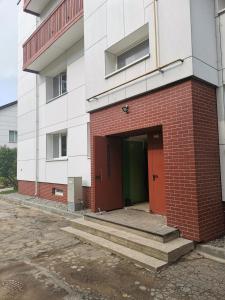 un edificio de ladrillo rojo con una puerta roja y escaleras en The good stay, en Šiauliai 12 fotos más