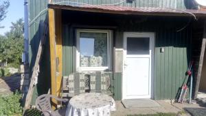 a small green house with a table and a door at Bauernhof Oase in Bestensee