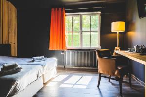 Schlafzimmer mit einem Bett, einem Schreibtisch und einem Fenster in der Unterkunft Domaine du Blé in Wavre