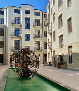 羅茲的住宿－Apartament Green - Piotrkowska 37，建筑前的游泳池中的雕塑