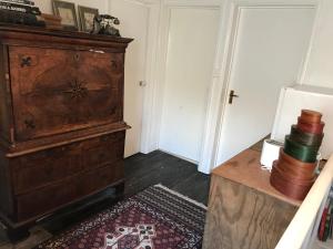 Cette chambre comprend une grande commode en bois et une table. dans l'établissement Half Moon House top flat, à Hay-on-Wye