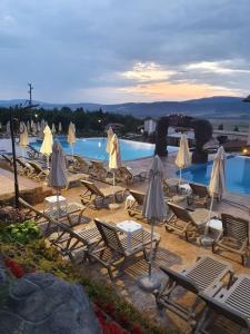 a group of chairs and umbrellas next to a pool at Vikeya Guest House in Sapareva Banya
