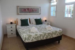 ラ・オリーバにあるVilla Chennai by Privilege Bayのベッドの上にキャンドルが2本置かれた寝室 +28枚の写真