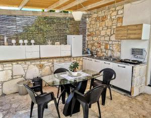 a kitchen with a table and chairs and a counter at Trullo Oasi Veronica in Ostuni