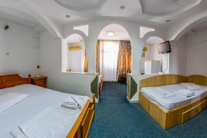 Cette chambre comprend 2 lits et une télévision. dans l'établissement Motel Dasiana, à Târgu Jiu