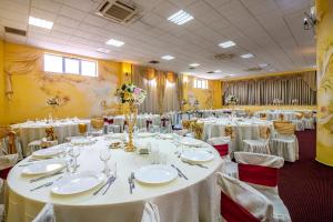 a room with tables and chairs with white tablecloths at Motel Dasiana in Târgu Jiu